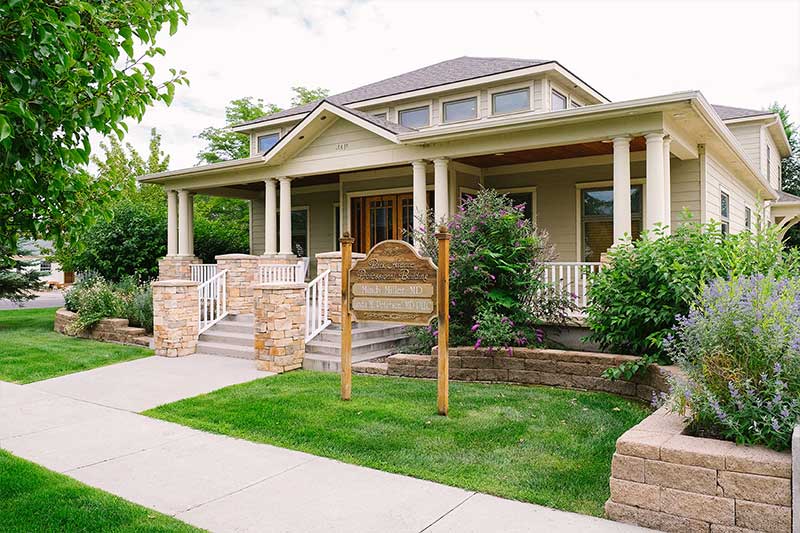 A house with a lot of green grass on the front lawn