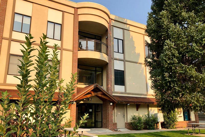 A building with many windows and trees in front of it