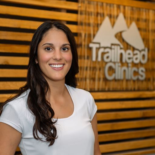 A woman standing in front of a sign.