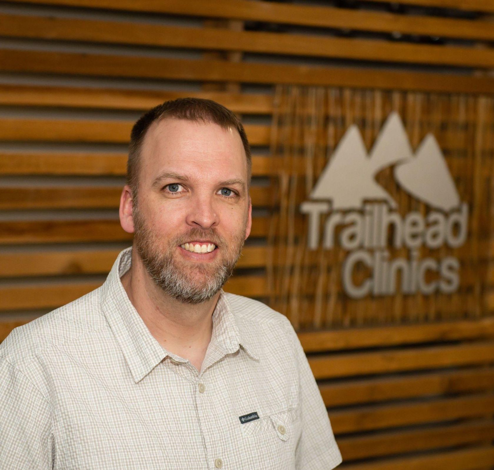 A man standing in front of a sign.