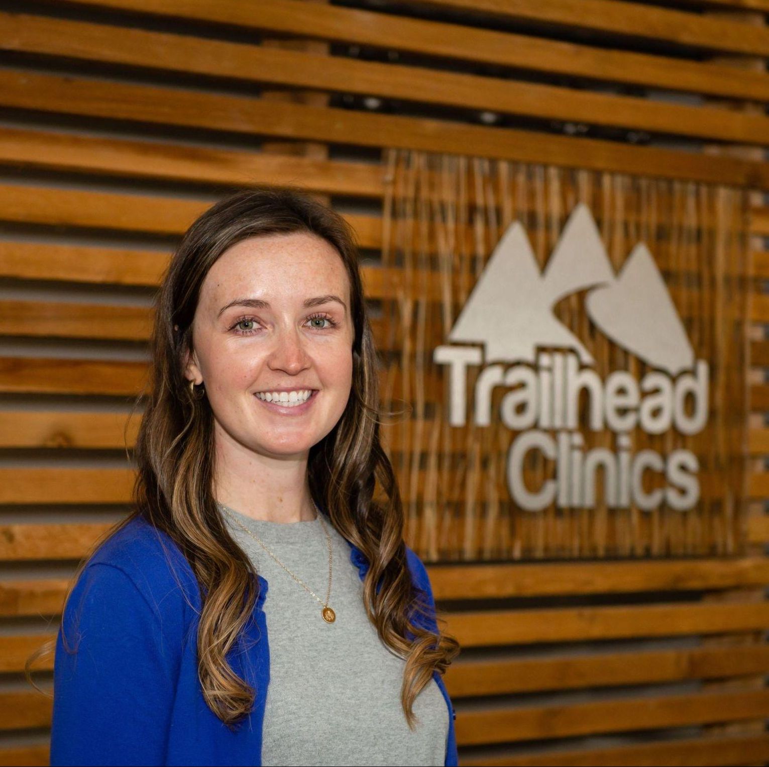 A woman standing in front of a sign.