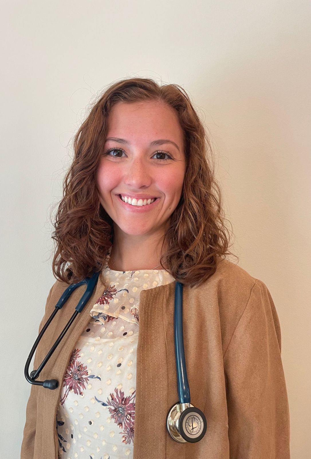 A woman with brown hair and a stethoscope around her neck.